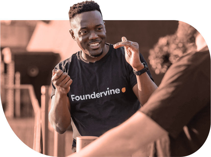 CEO of Foundervine, Cecil Adjalo, is smiling and gestures with his hands in conversation. Cecil is a young Black man with a short beard.