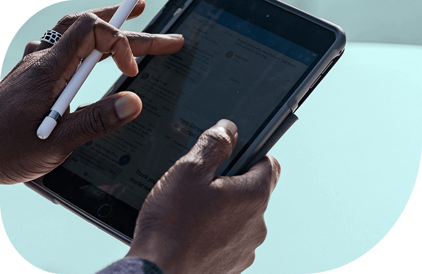 Close up of a Black person's hands using an electronic tablet and stylus.