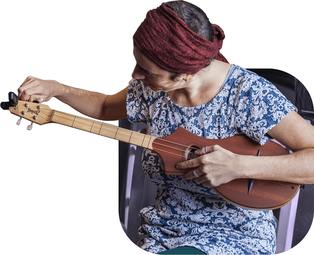 A social entrepreneur tunes a stringed instrument.